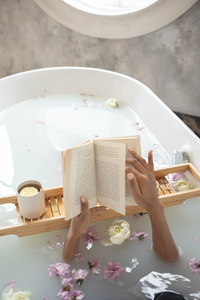 A tranquil scene of relaxation, reading a book in a flower-filled bathtub.