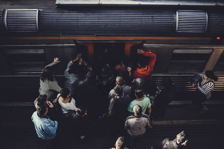 Aerial view of a group of commuters boarding a train at a station.